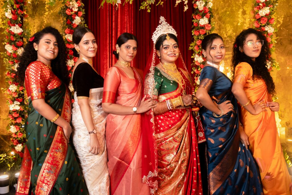 Indian bride in traditional attire with bridesmaids in vibrant sarees. Joyful celebration.